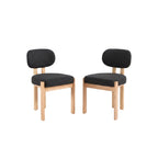 Dining table with two black chairs in a room with light-colored walls and decor.